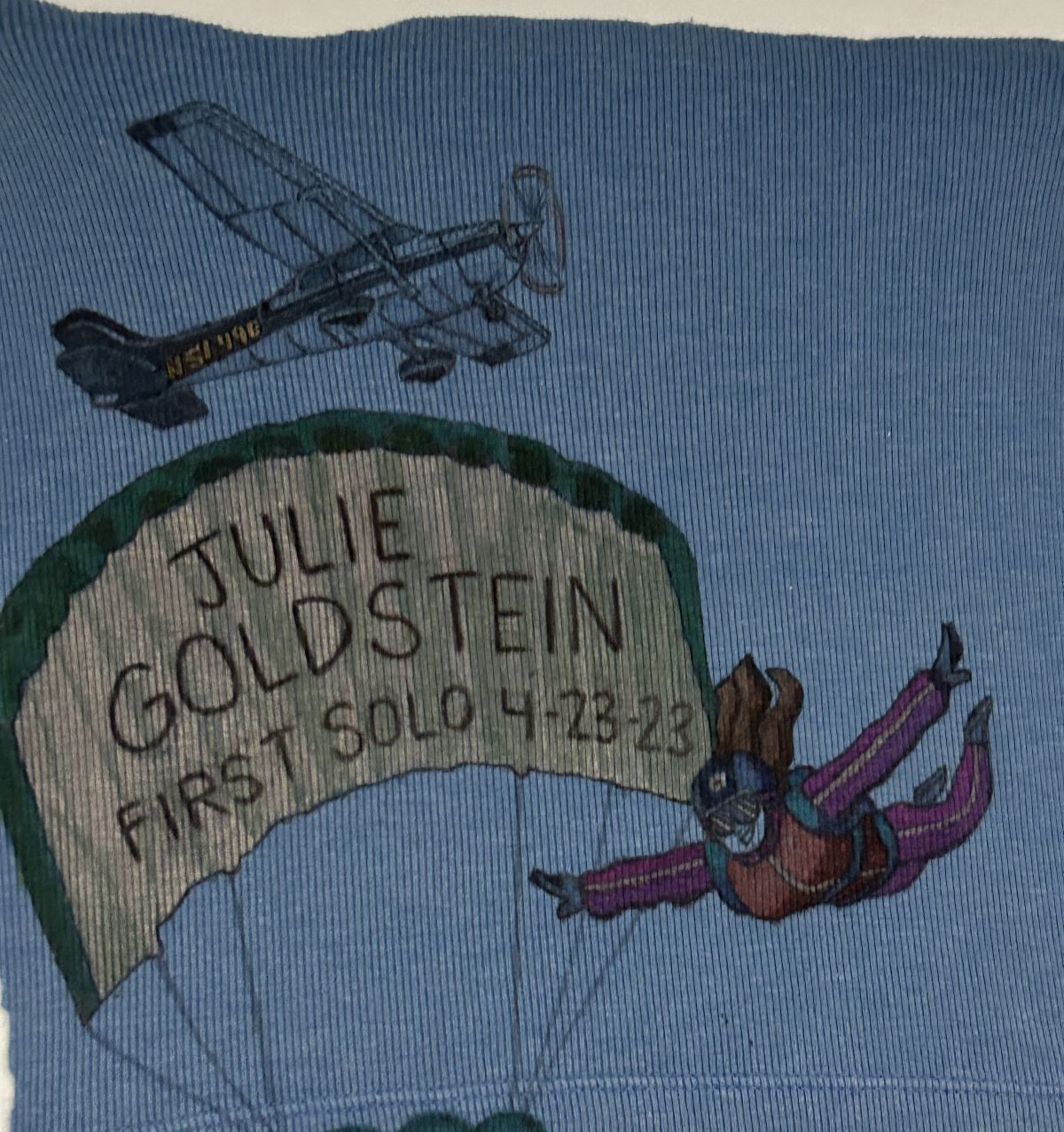 Julie Goldstein's cut shirt with writing representing their first solo flight