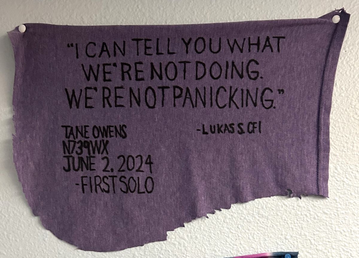 Tane Owens' cut shirt with writing representing their first solo flight