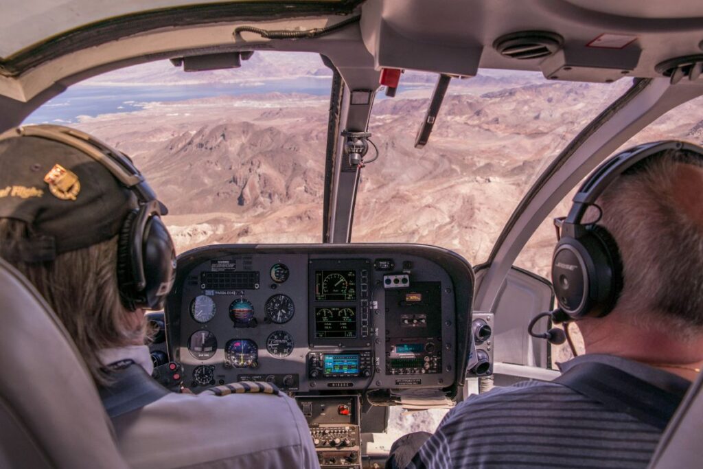 Pilots in the cockpit with a view of a mountain range